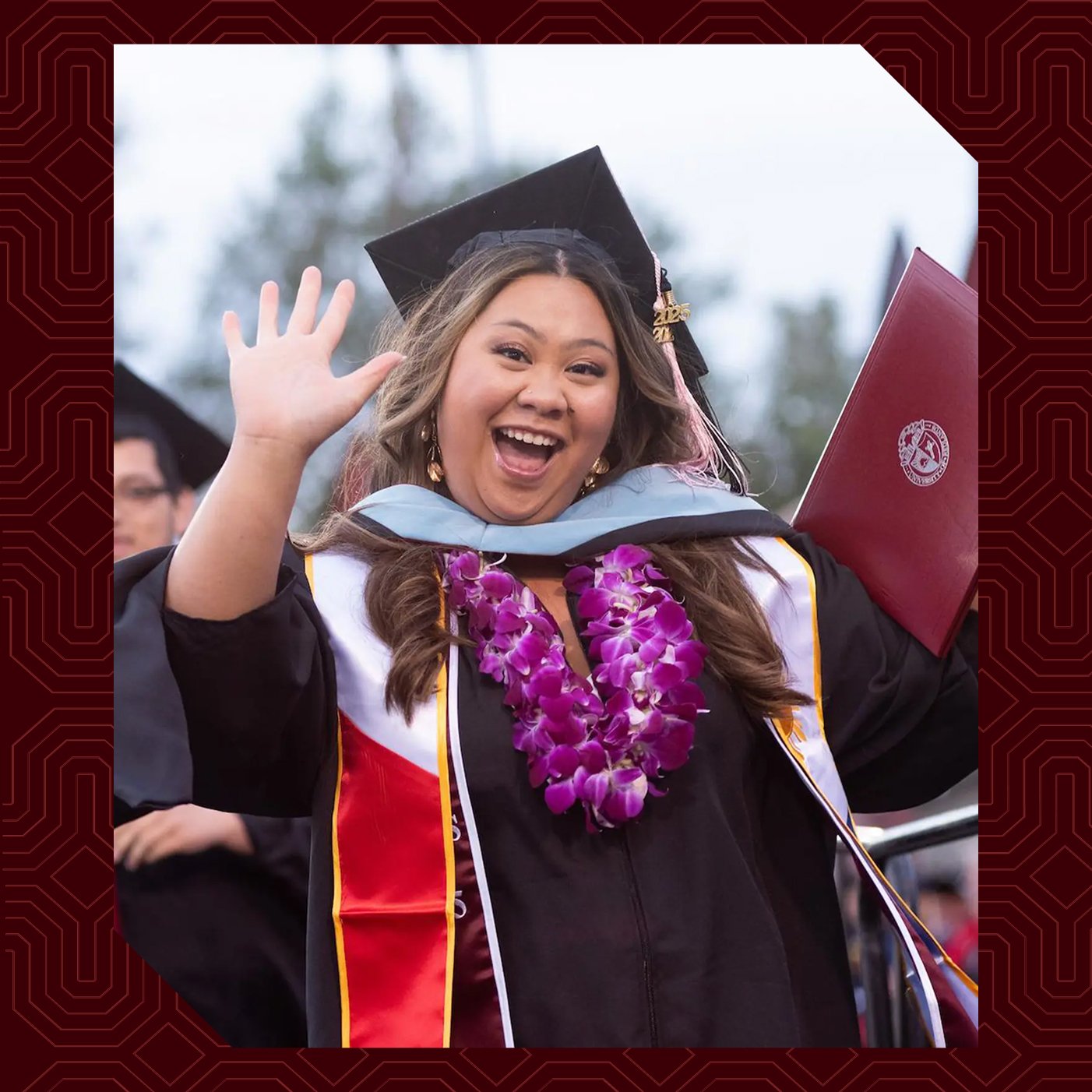 a woman in a graduation gown waving