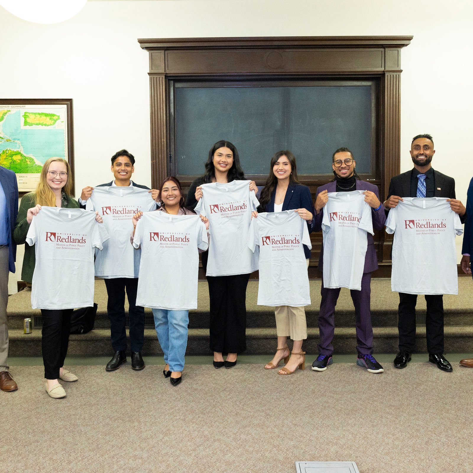 a group of people holding up shirts