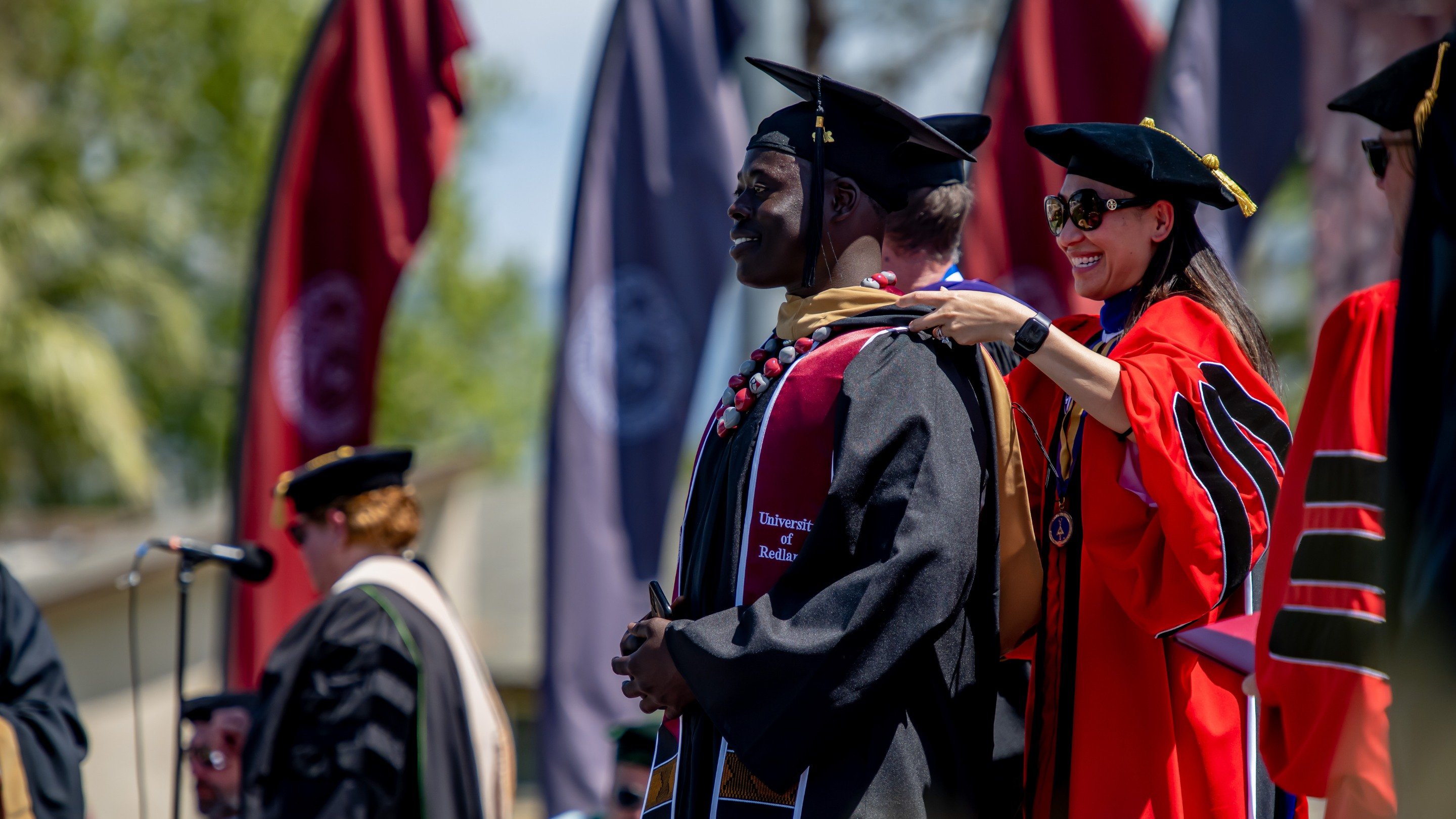a woman putting on a graduation gown