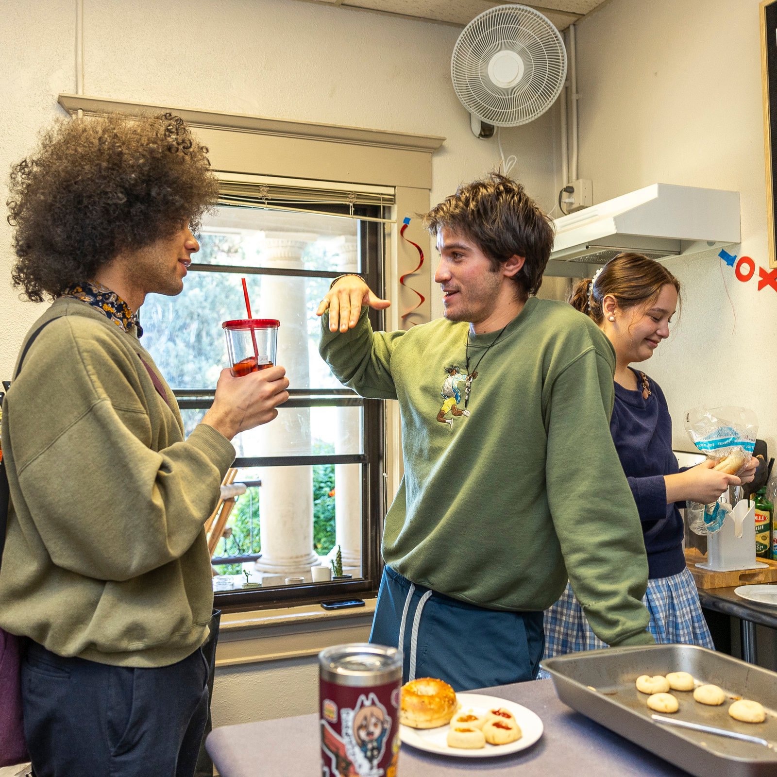 a group of people standing in a kitchen