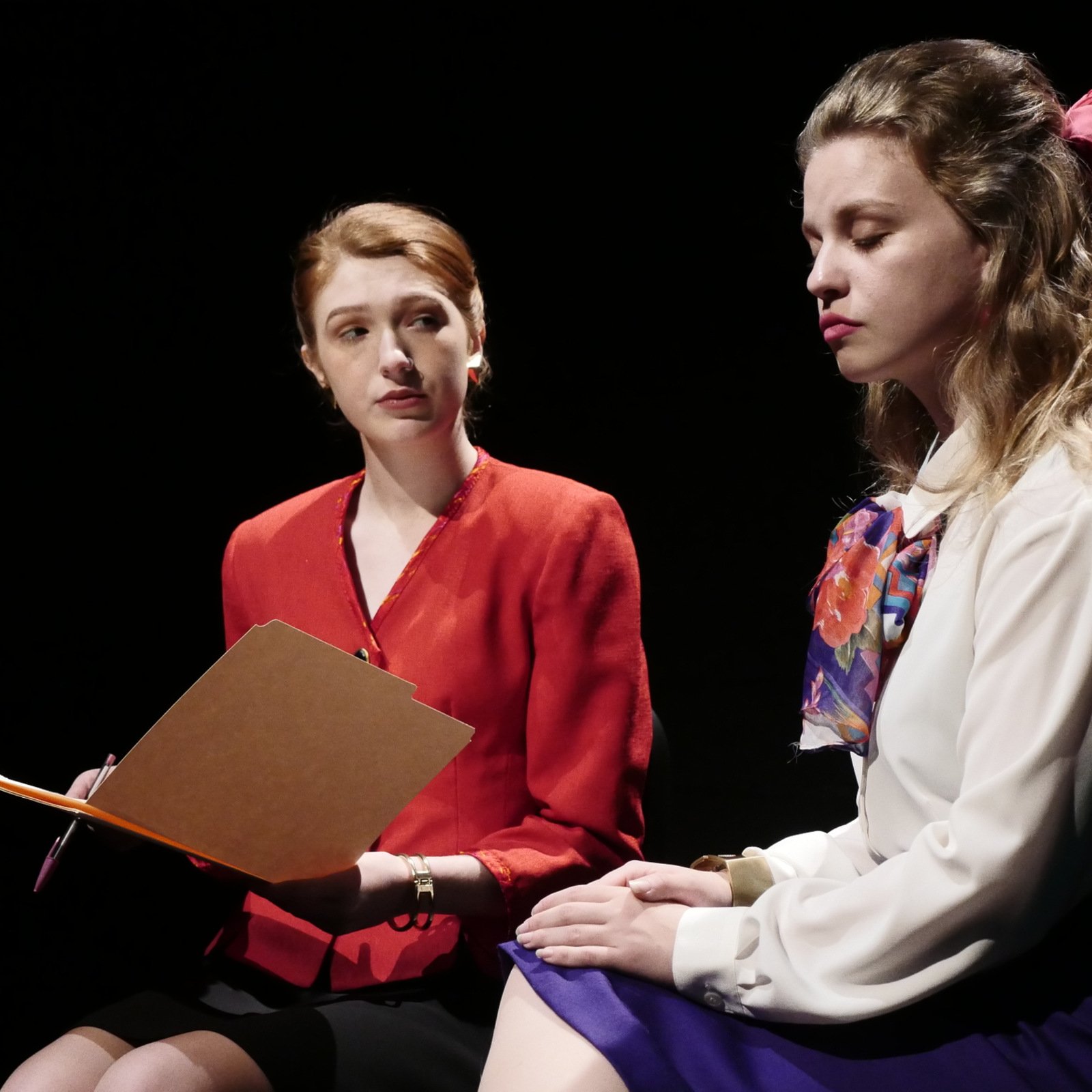 a woman sitting next to another woman