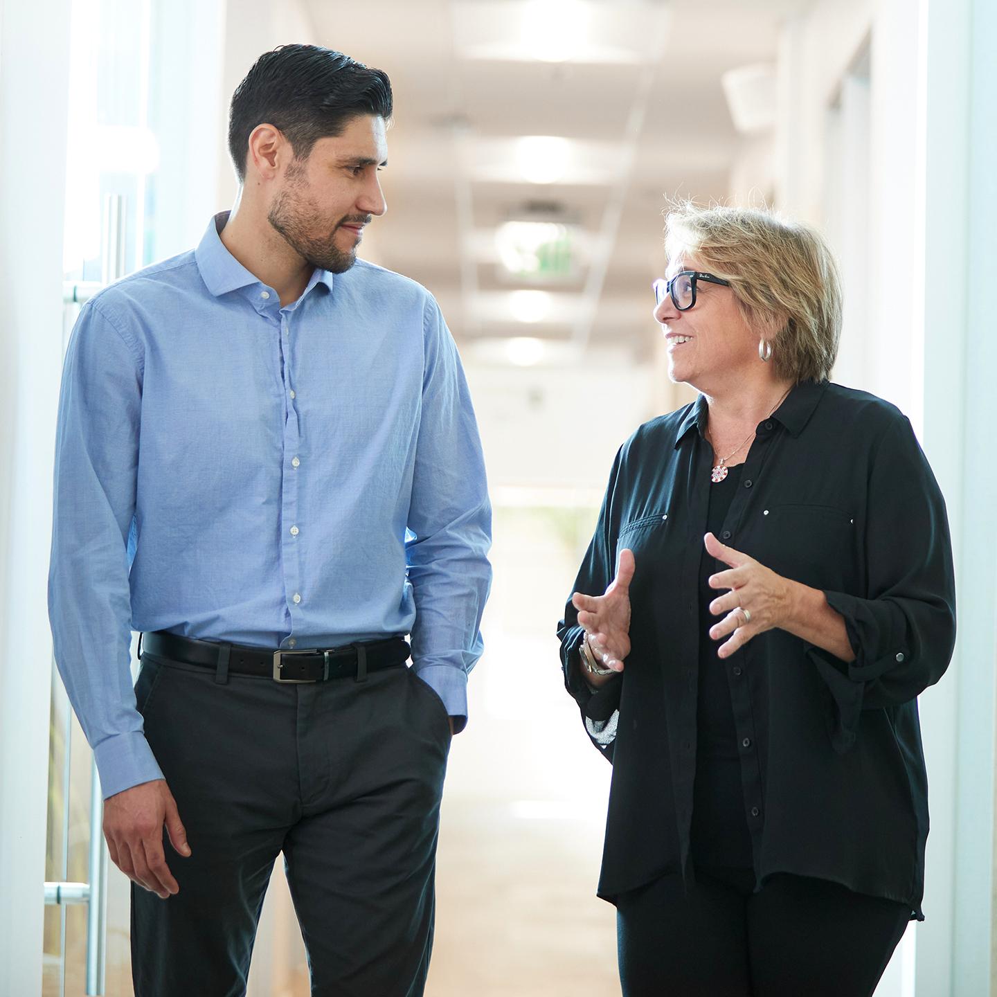 a man and woman talking in a hallway