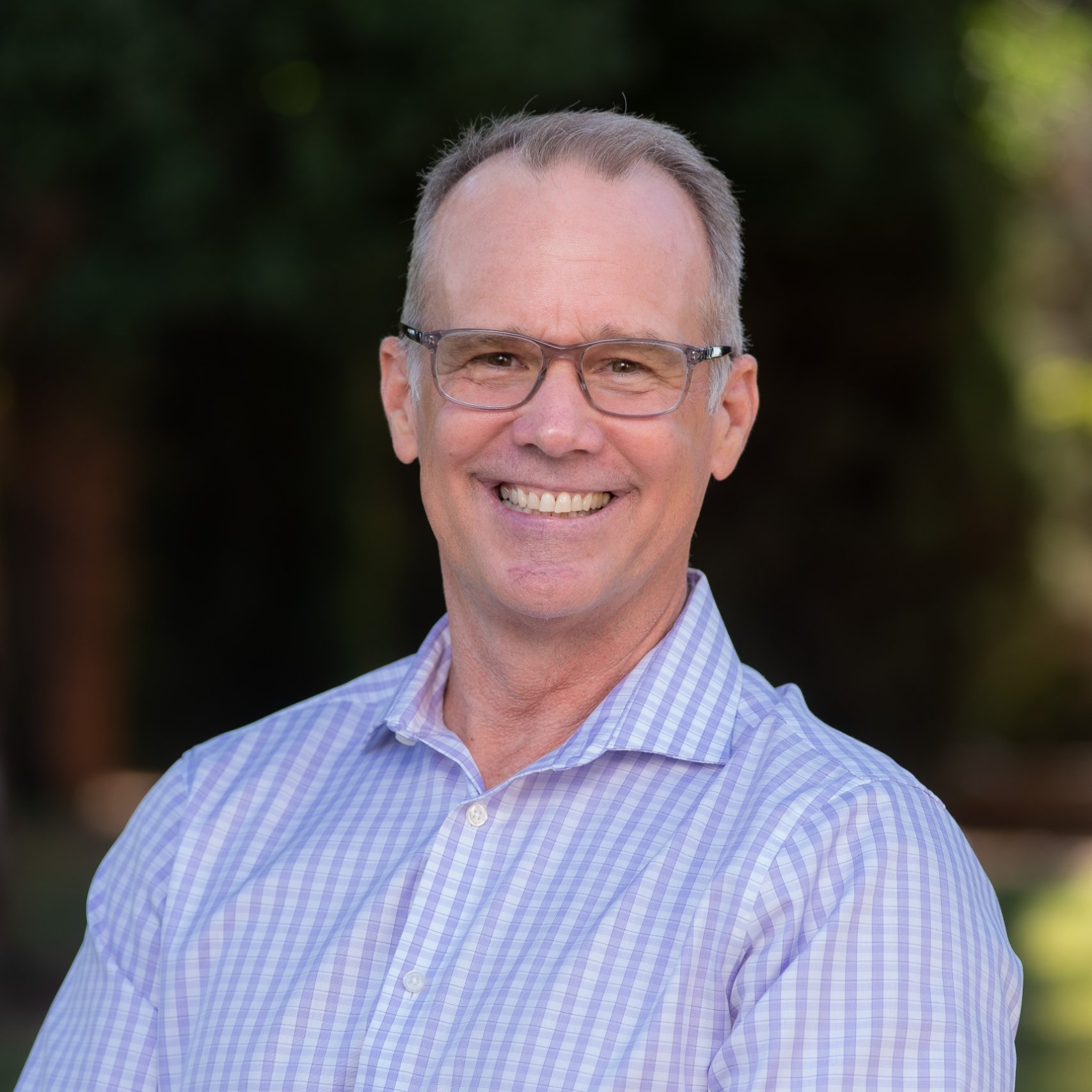 a man wearing glasses smiling