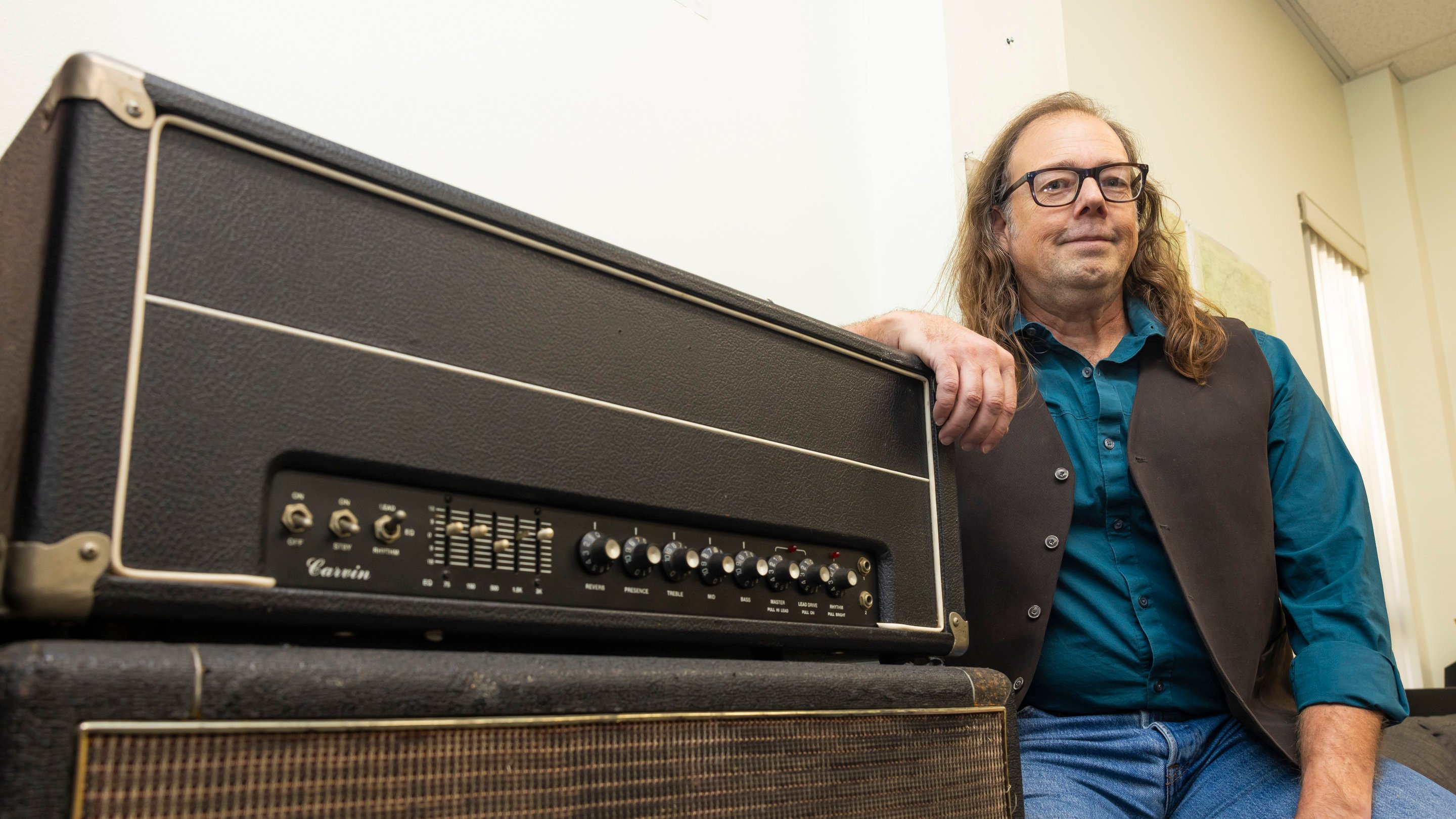 a man leaning on a amplifier