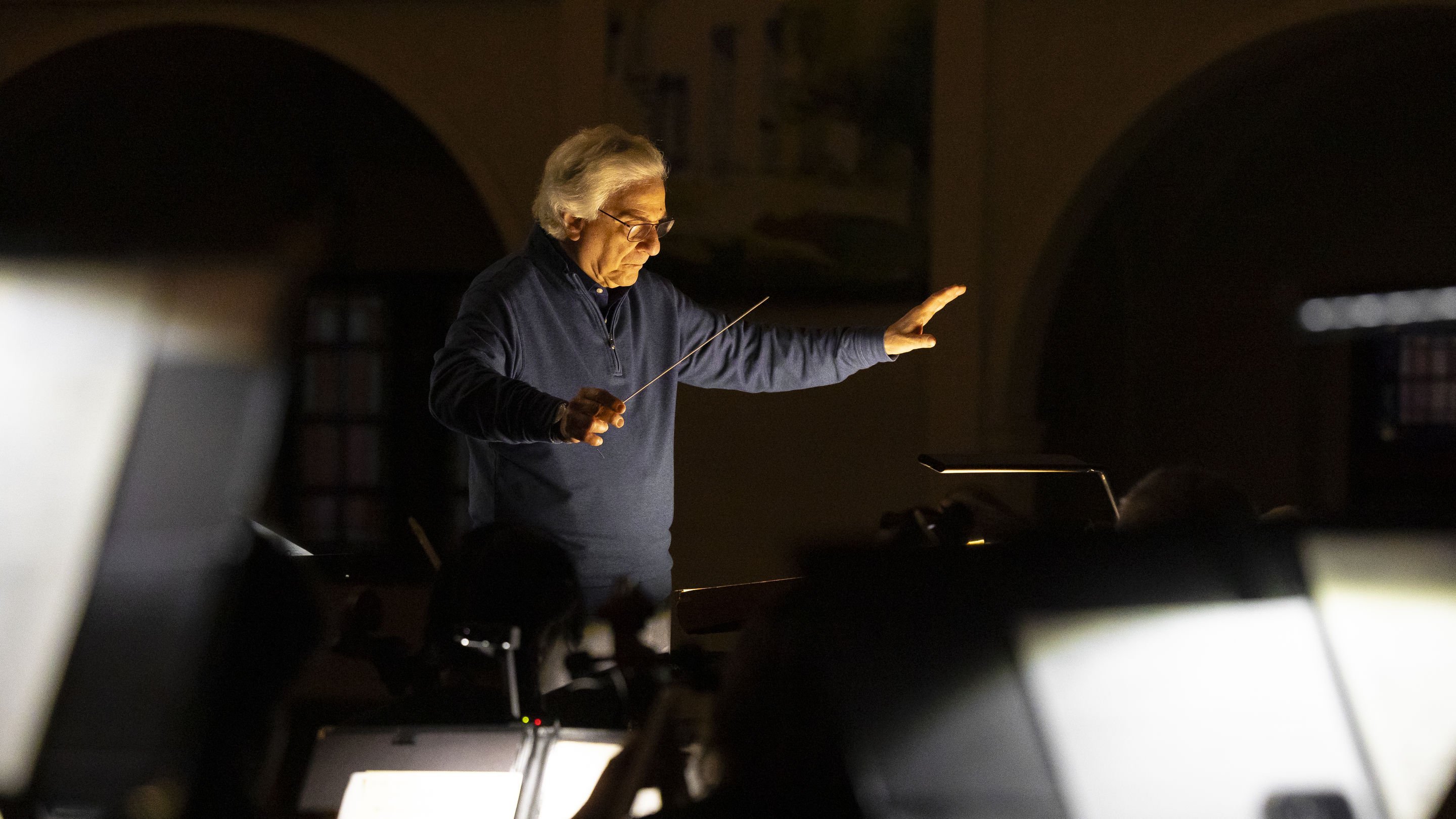 a man holding a stick in front of a piano