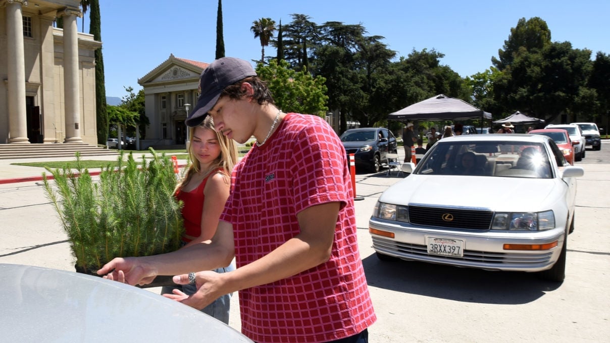 a man in a red shirt and black hat standing next to a woman in a red shirt