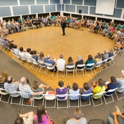 a group of people sitting in chairs in a circle