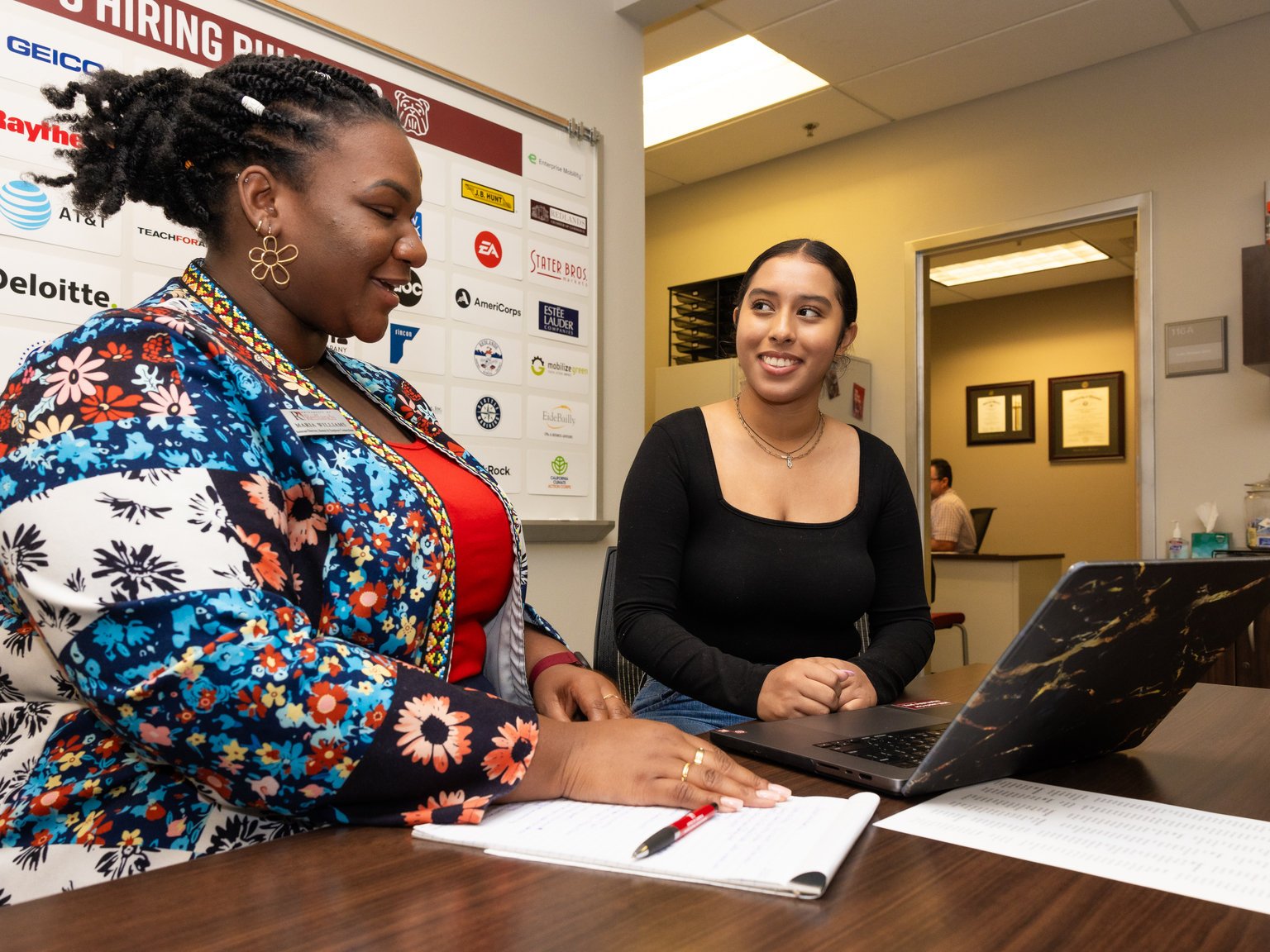 a woman sitting at a desk with a laptop