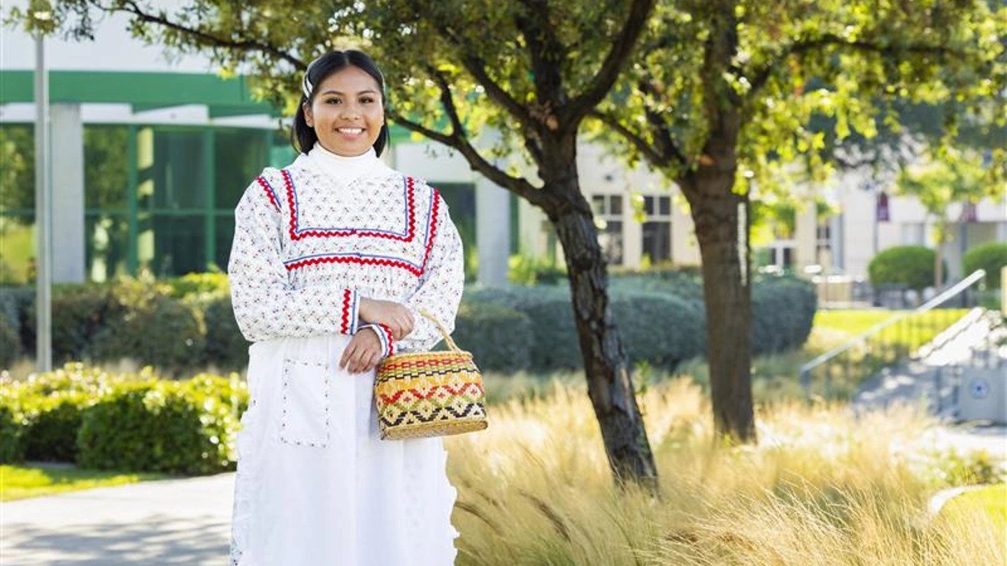 a woman in a white dress holding a woven basket