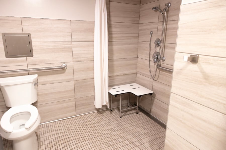 a shower with a bench and shower head