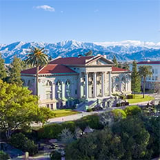 a building with trees and mountains in the background