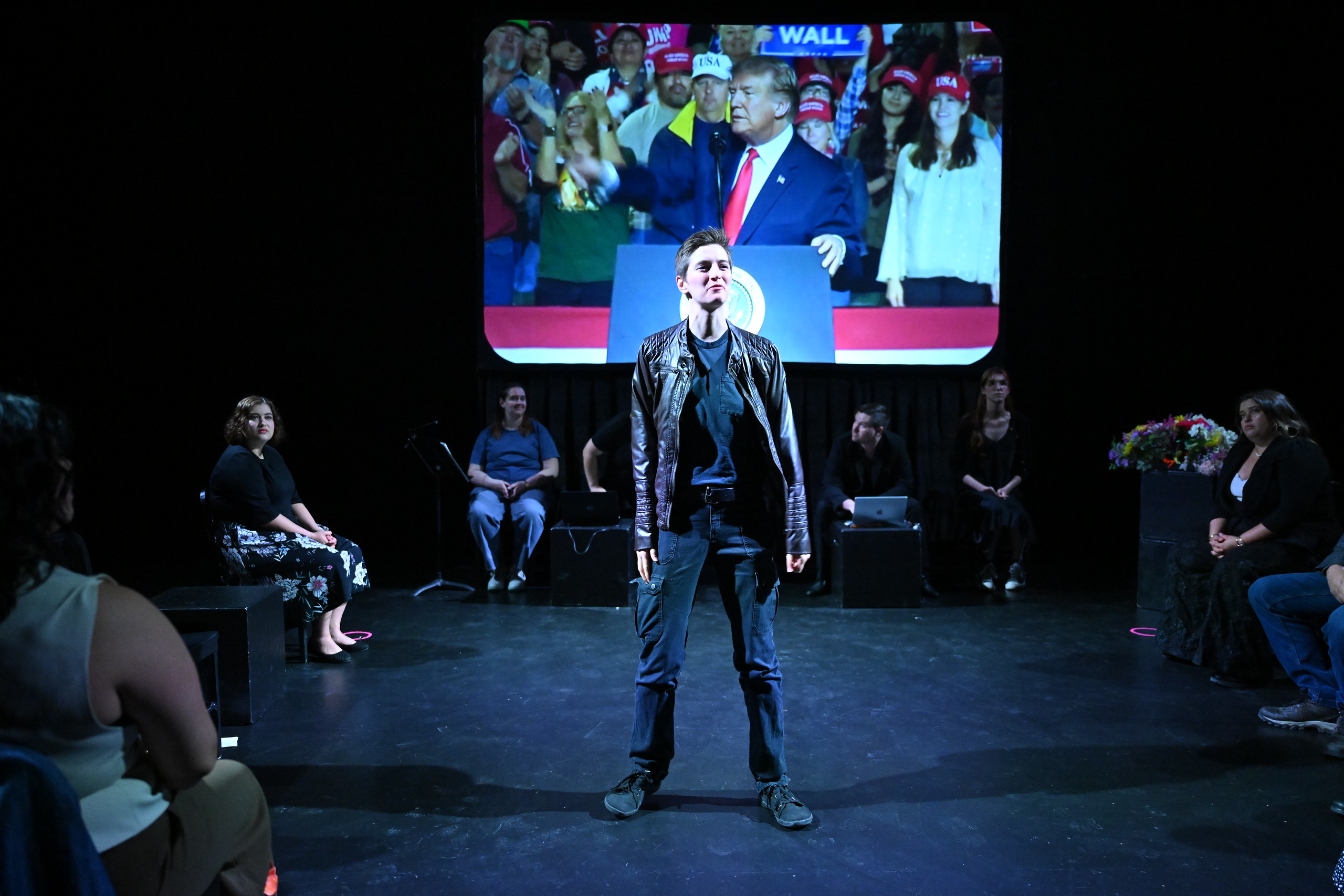 a man standing on a stage with a crowd watching