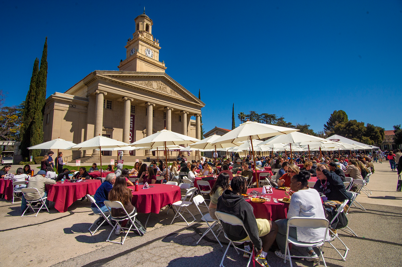 a group of people sitting at tables outside a building