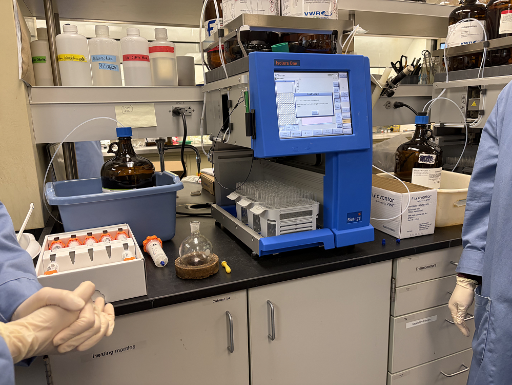 a blue machine with a screen and containers on a black counter