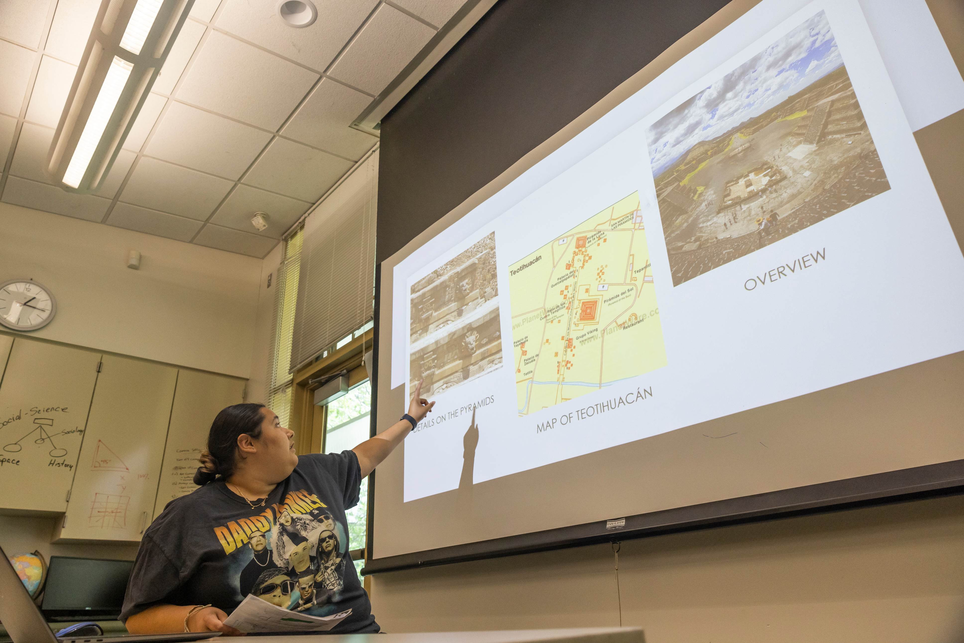 a woman pointing at a projector screen