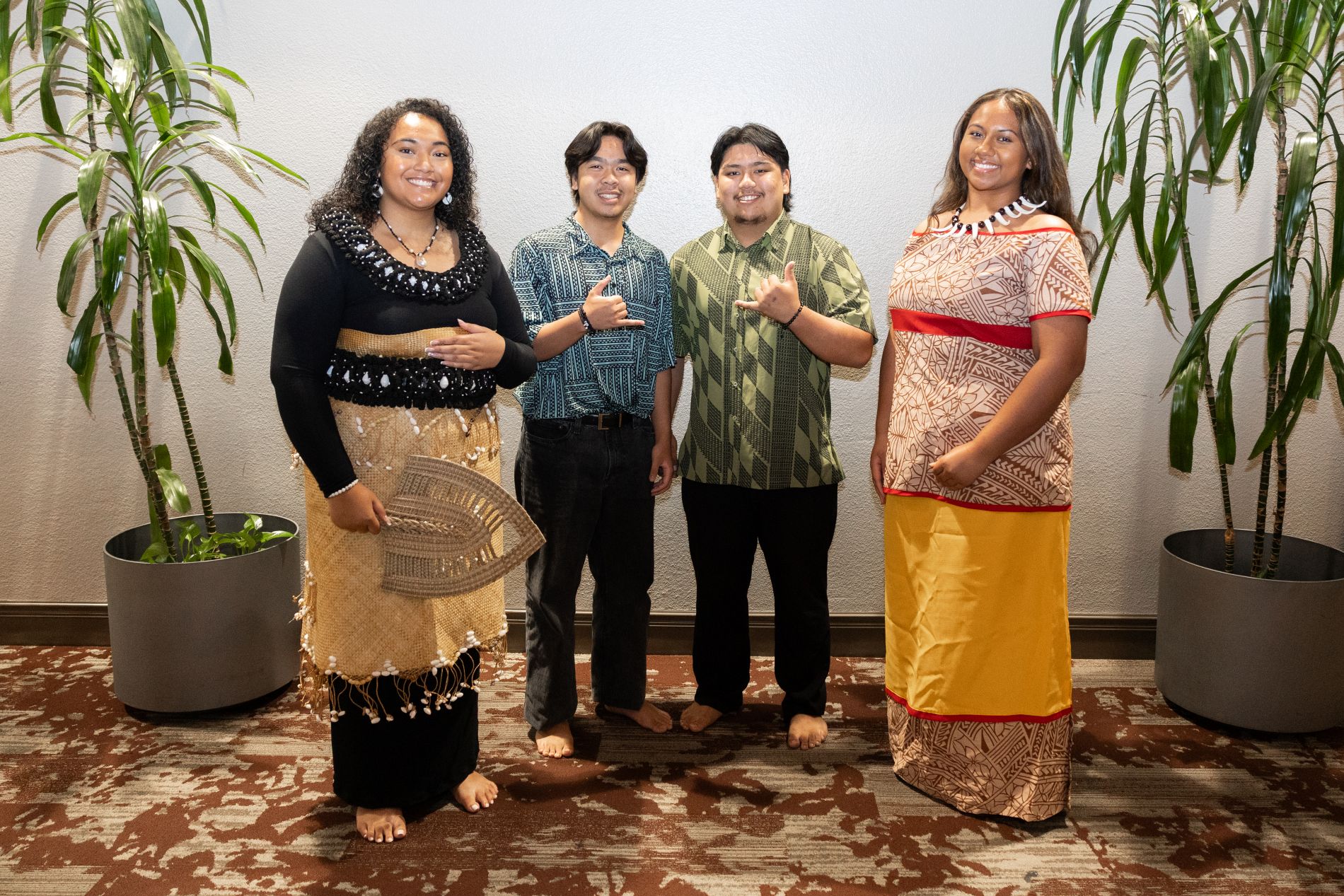 Four students from the Polynesian Voyagers of Redlands organization pose in traditional regalia at a campus cultural event.